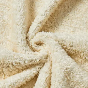 Détail macro montrant la texture douce du tissu polaire sherpa de couleur crème