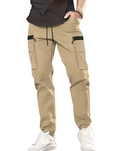 Detail view of khaki multi-pocket cargo pants featuring zipper and drawstring waist.
