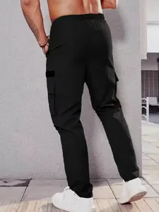 Rear view detail of men's black multi-pocket cargo pants featuring elastic waist and casual fit