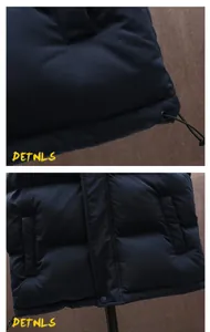 Close-up details of men's navy thick puffer vest showing pockets and hem drawstrings.