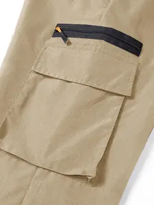 Close-up of khaki cargo pants pocket detail with black zipper and flap construction