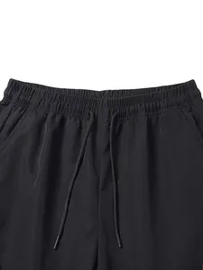 Close-up detail showing the elastic waistband and adjustable drawstrings of black cargo pants