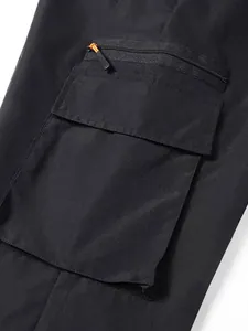 Detailed view of the multi-functional cargo pocket on black outdoor tactical pants.