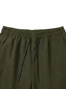 Close-up detail of elastic waistband and black drawstring on olive green cargo pants