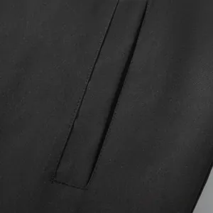 Close-up detail of reinforced stitching on black windproof jacket pocket flap.