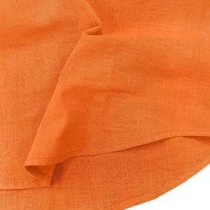 Detailansicht der hochwertigen orangen Leinenstruktur und des runden Saums eines Herrenhemdes