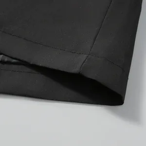 Detailed macro view showing the high-quality stitching on a black windbreaker jacket hem.