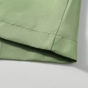 Macro view of the high-quality stitching and green fabric texture on a windproof jacket