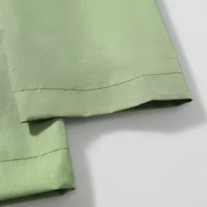 Detailed close-up showing the double stitching on a light green men's windbreaker jacket cuff.