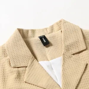 Detailansicht des Waffelstrickstoffs an einem lässigen Herrenblazer-Kragen mit Etikett
