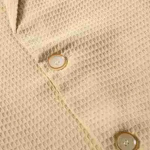 Makro-Detailaufnahme eines Herren-Casual-Blazers mit beiger Waffelstrick-Textur.