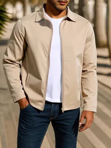 Men's khaki zip-up windproof jacket styled with a white t-shirt and blue jeans outdoors