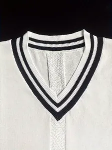 Dettaglio del gilet in maglia bianca con scollo a V a righe nere in stile collegiale
