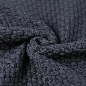 Primer plano del tejido de punto jacquard gris oscuro con textura de patrón de gofre