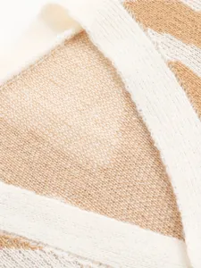 Macro detail of the soft knitted texture on this beige and white striped fashion cardigan.