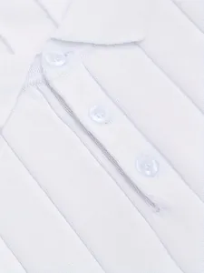 Primer plano detallado de un polo de punto blanco con rayas y botones frontales clásicos
