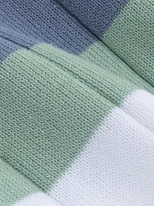 Vista macro del suave tejido de punto con rayas azules, verdes y blancas.