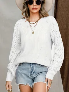 Primo piano di un maglione lavorato a maglia bianco con motivo a rombi su una modella