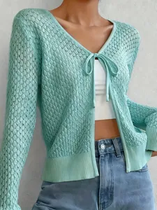 Vista dettagliata di un cardigan in maglia traforata verde menta con fiocco frontale