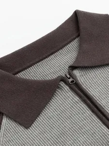Detailed macro view of a men's contrast color polo knit sweater featuring a sleek half-zipper.
