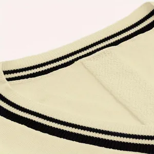 Primo piano di un gilet in maglia con scollo a V e strisce nere a contrasto sul collo
