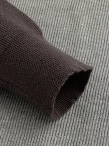 Close-up detail of the ribbed knit cuff on a dark brown men's business casual sweater.