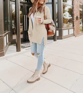 Fashionable long cream open front knit cardigan worn by woman walking on the street