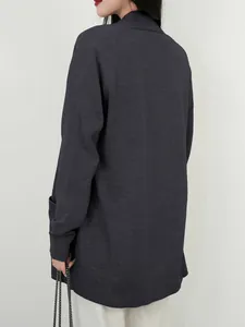 Detail van de achterkant van een donkergrijs gebreid damesvest met handige zijzakken.
