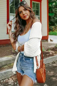 Close-up detail of a white lightweight ribbed knit cardigan for women styled with denim shorts