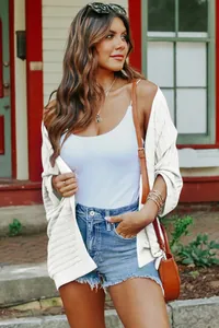 Detailed view of women's white ribbed knit cardigan featuring lightweight five-point sleeves