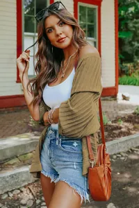 Model wearing olive green ribbed knit cardigan with half sleeves in outdoor setting