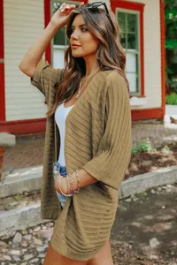 Close-up detail of textured ribbed knit on brown half-length sleeve cardigan jacket