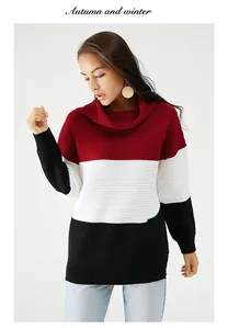 Détail d'un pull en maille color-block avec des rayures rouges, blanches et noires.