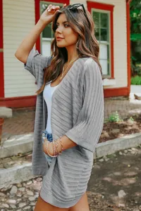 Grey women's knit cardigan with thin five-point sleeves in a casual outdoor setting