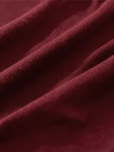 Macro view of burgundy knitted fabric texture for soft men's V-neck sweater vest garment
