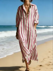 Relaxed V-neck pink and white striped maxi dress worn by a model on a sunny beach setting