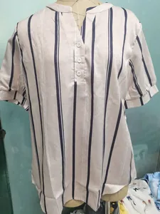 Close-up detail of vertical striped short sleeve blouse with V-neck button closure