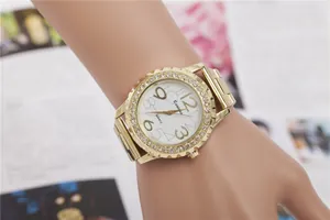Elegant gold-toned ladies quartz watch with a sparkling rhinestone bezel on a wrist