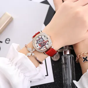 Close-up of a women's quartz watch with a red strap and a butterfly rhinestone bracelet
