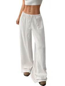 Vue détaillée de la texture gaufrée d'un pantalon large blanc en coton et lin léger.