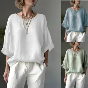 Detailed view of casual loose linen blouse showing white, blue, and sage green colors