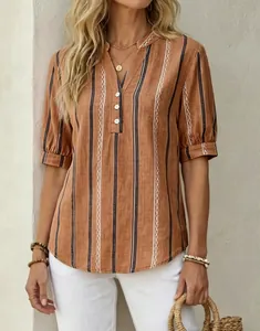 Detail of women's terracotta striped V-neck blouse with embroidered patterns.