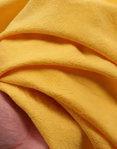 Primo piano del tessuto traspirante in cotone e lino lavato giallo con consistenza