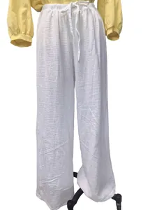 Détail du pantalon large en coton et lin blanc avec texture froissée et cordon de serrage.