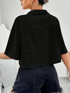 Detailed back view of a solid black cropped button-up shirt with textured fabric finish