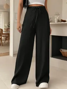 Détail d'un pantalon noir à taille haute et jambes larges avec un cordon de serrage