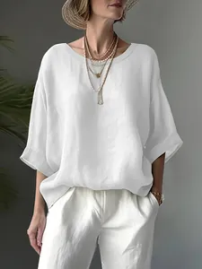 Detailed view of a white loose-fitting short sleeve linen blouse for women in casual style