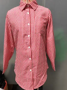 Détail du motif à carreaux rouge et blanc sur une chemise à manches longues avec une poche poitrine