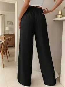 Vista posteriore dei pantaloni neri a vita alta e gamba larga da donna.