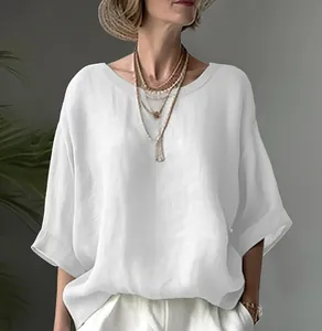 Close-up detail of a breathable white loose-fitting round-neck linen blouse on a model